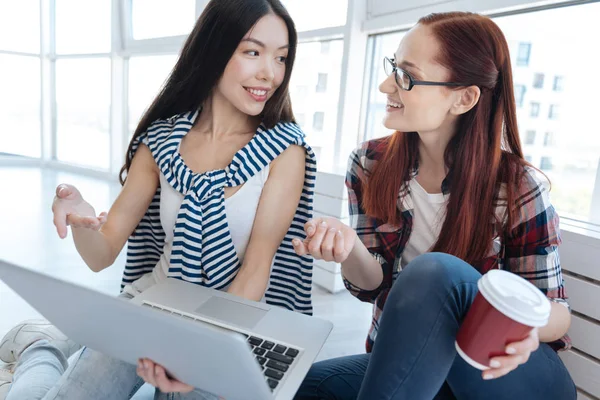 Mujeres jóvenes y alegres discutiendo su startup — Foto de Stock