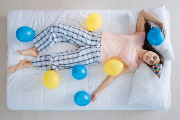 Freudige schöne Frau, die von Luftballons umgeben ist — Stockfoto