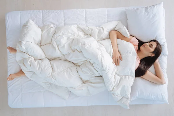 Милая молодая женщина, покрывающая себя одеялом — стоковое фото