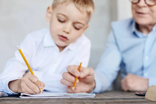 Persistent kid and his grandpa preparing for school together — Stock Photo, Image