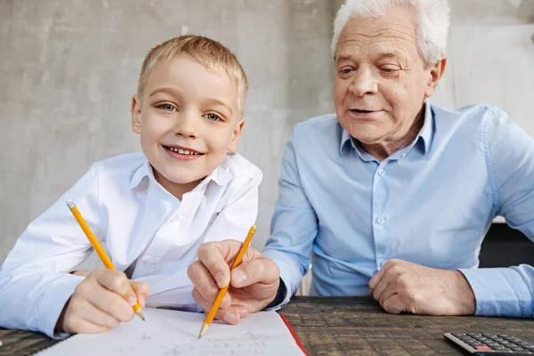 学校のタスクと彼の孫を助ける魅力的な巧妙な男 — ストック写真