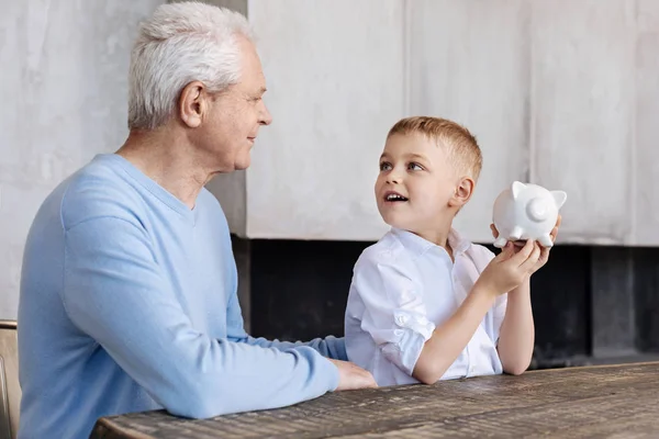 Vidám, élénk fiú hallgat grandpas előadás a gazdaság — Stock Fotó