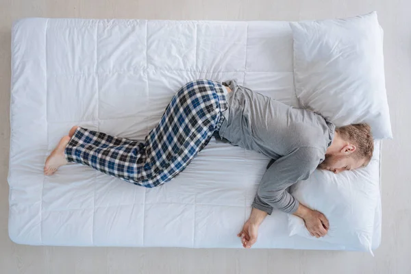 Schöner friedlicher Mann ruht sich in seinem Bett aus — Stockfoto