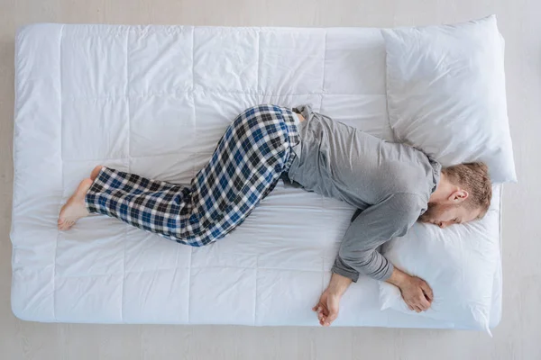 Bonito homem pacífico descansando em sua cama — Fotografia de Stock