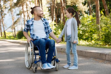 Gülümseyen erkek kişi çocuğunu elini tutarak sakallı
