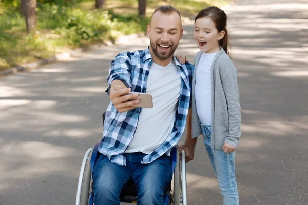 Padre e hija positivos mirando directamente al teléfono —  Fotos de Stock