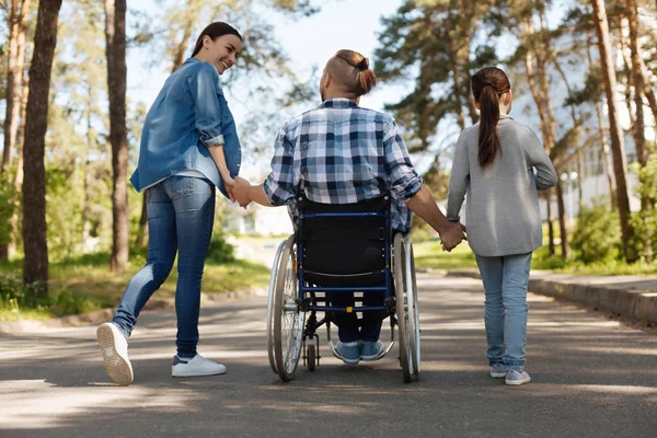 Invalid man holding hands of his daughter and wife — Stock Photo, Image