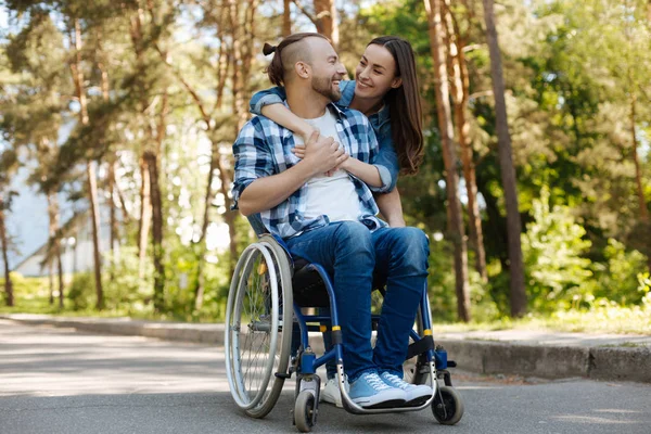 Uśmiechający się niepełnosprawny człowiek ogląda jego dziewczyna — Zdjęcie stockowe