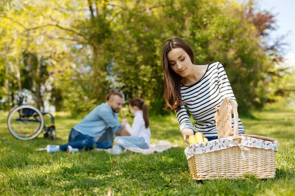 Mooie vrouw nemen van bananen uit de mand — Stockfoto