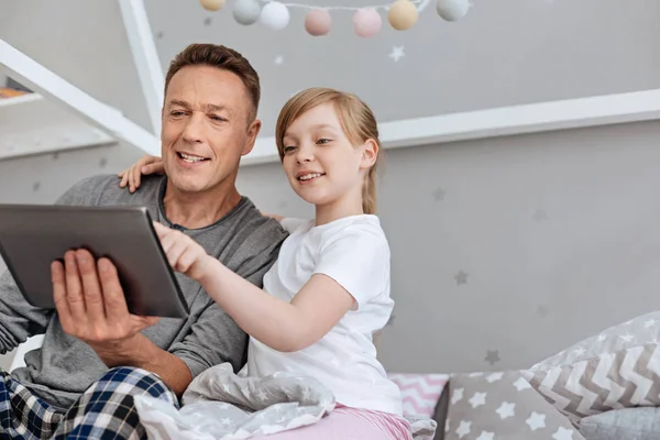 Linda familia comprometida viendo algo en la tableta — Foto de Stock