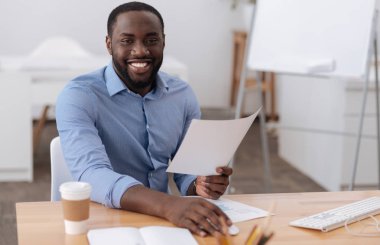 Masada oturan neşeli pozitif adam