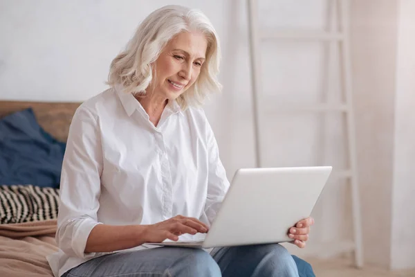 Ältere Frau hält Laptop in der Hand — Stockfoto