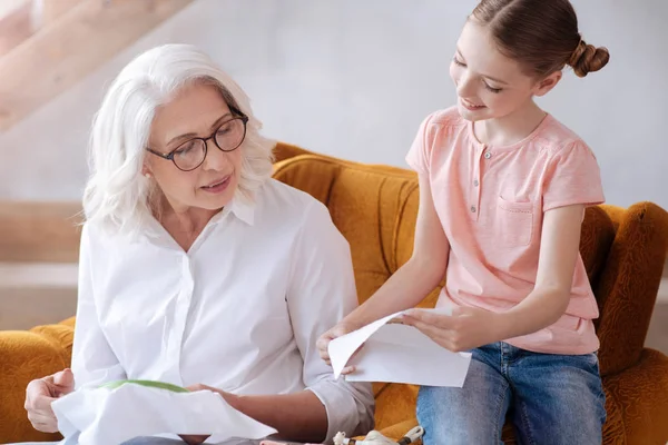 Delighted nice girl showing her work to the grandmother — Stock Photo, Image