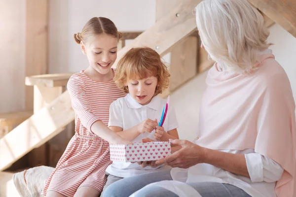 Curiosi bambini felici guardando i loro regali — Foto Stock