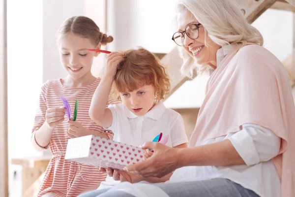 Lycklig glad kvinna ger julklappar till barnbarnen — Stockfoto