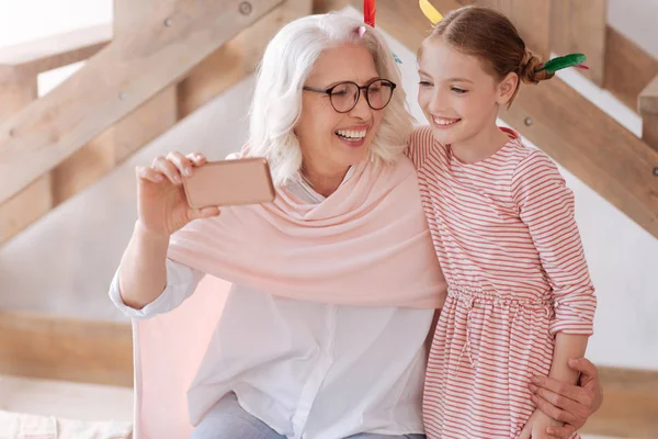 Vrolijke aangename vrouw haar kleindochter knuffelen — Stockfoto