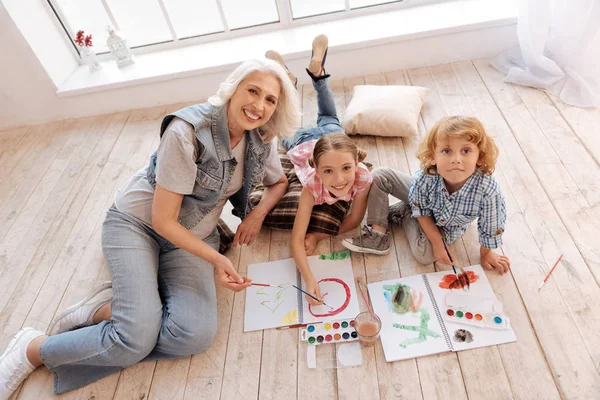 Delighted joyful kids lying on the floor — Stock Photo, Image