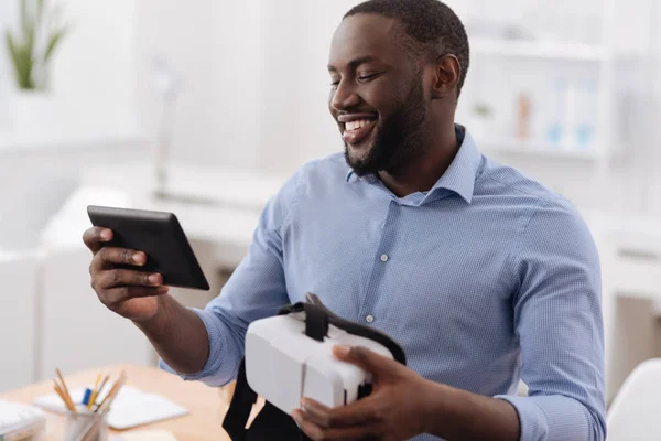 Homem alegre positivo olhando para a tela do tablet — Fotografia de Stock