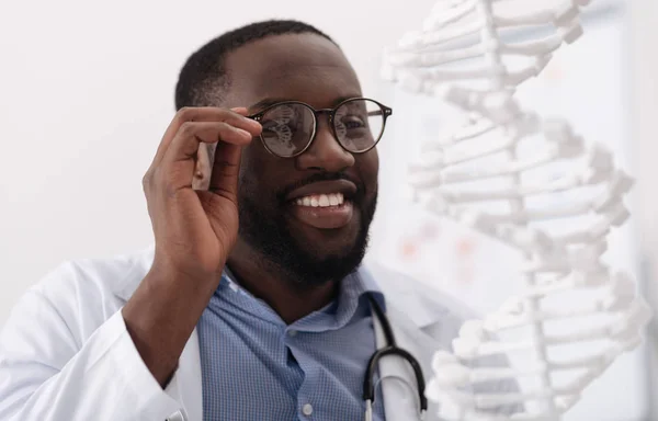 Cientista encantado positivo segurando seus óculos — Fotografia de Stock