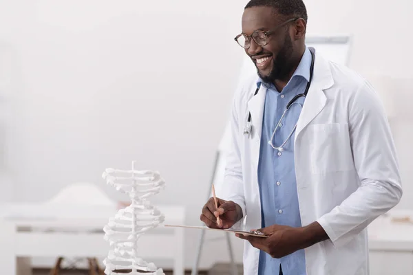 Inteligente científico guapo estudiando ADN humano — Foto de Stock