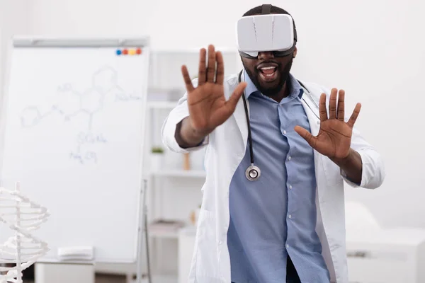 Bonito profissional médico pressionando as mãos para a tela virtual — Fotografia de Stock