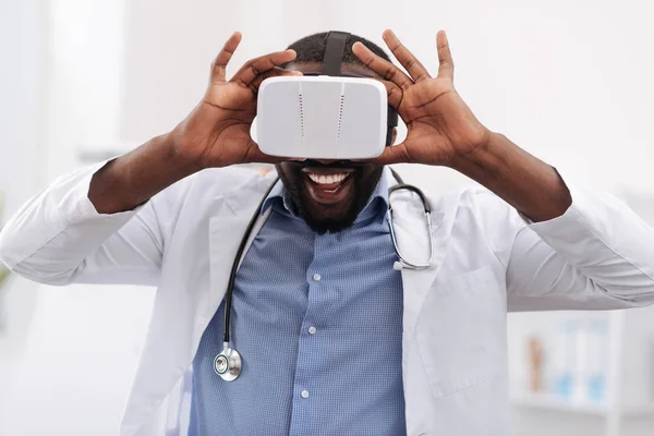 Médico alegre encantado usando óculos de realidade virtual — Fotografia de Stock