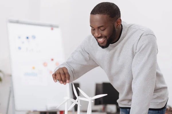 Joyful delighted man looking at the windmill models — Stock Photo, Image
