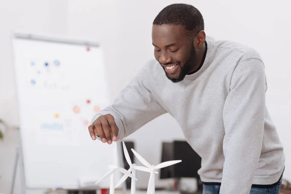 Freudestrahlender Mann beim Anblick der Windmühlenmodelle — Stockfoto