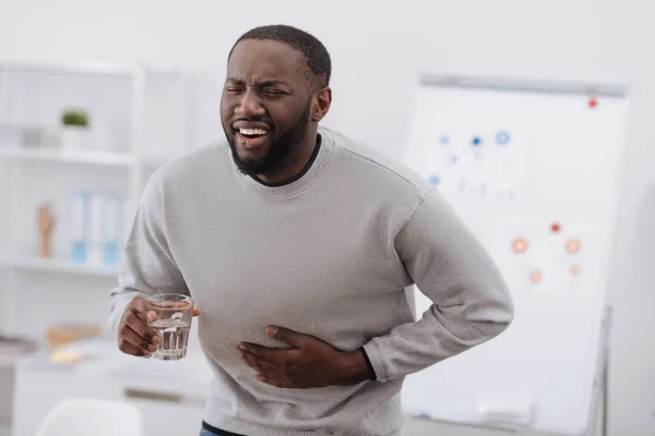 Moody adulto hombre sosteniendo un vaso de agua — Foto de Stock