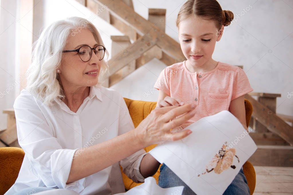 Nice pleasant woman helping her granddaughter