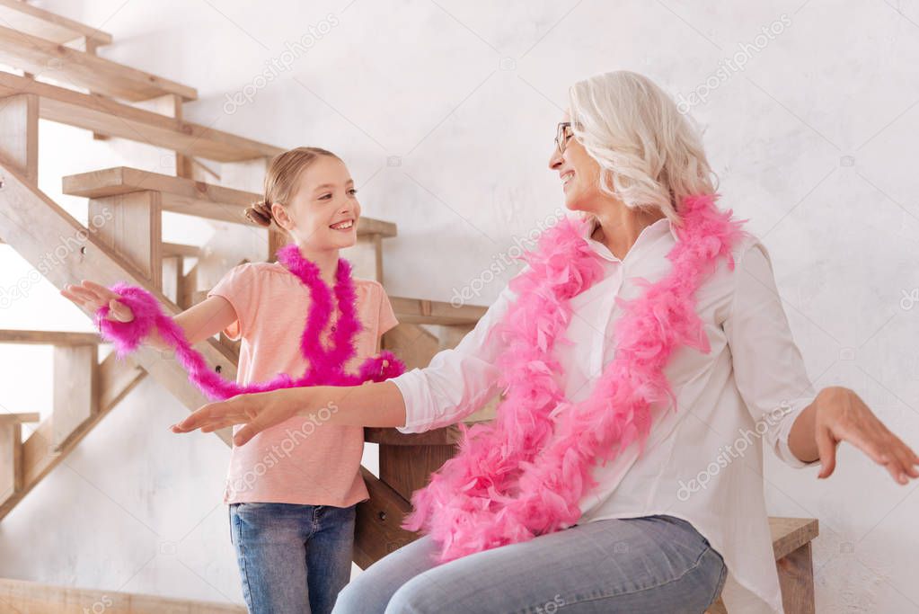 Delighted positive grandmother and granddaughter having fun together