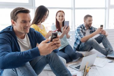 Neşeli yakışıklı smartphone ekrana bakarak