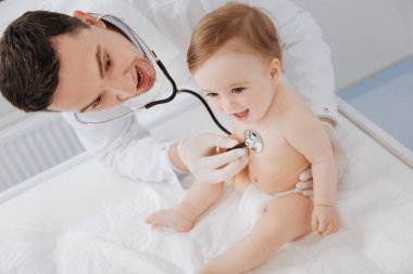 Onun küçük hasta gülmek yapma dikkatli esprili çocuk doktoru
