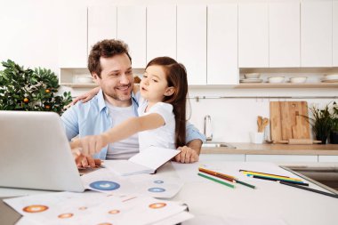 Laptop dönük ve eğlenceli bir şey söyleyerek kızı