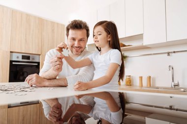 Baba ve kızı jigsaw puzzle parçaları eşleştirmek çalışıyor