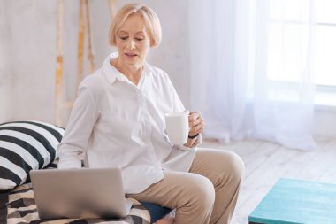 Oturma odasının ışık odasında memnun yaşlı kadın