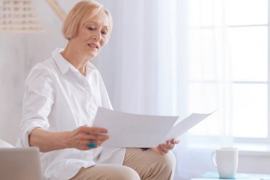 Çok ciddi yaşlı kadın belgelerden bilgi okuma