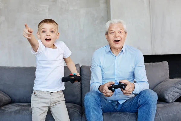 子供とおじいちゃんが一緒にビデオゲームをプレイ — ストック写真
