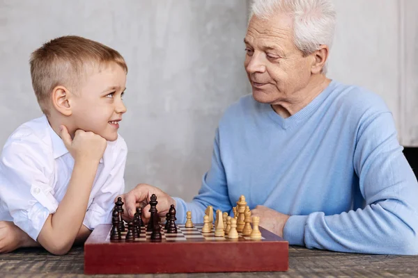 Charming nice grandpa teaching his grandson