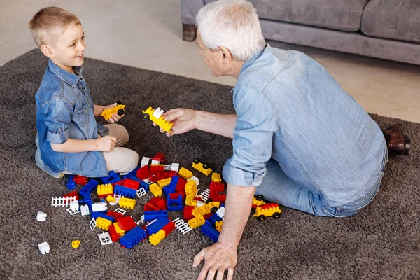 Adorable abuelo ayudando a su nieto durante el juego — Foto de Stock