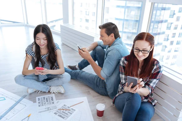 Glada positiva människor som håller sina smartphones — Stockfoto