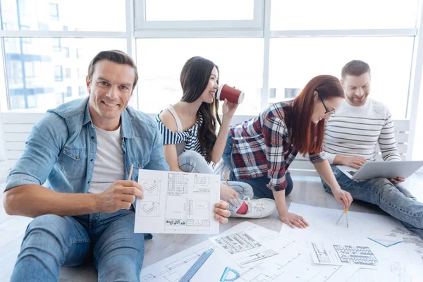 Alegre buen hombre que le muestra un dibujo —  Fotos de Stock