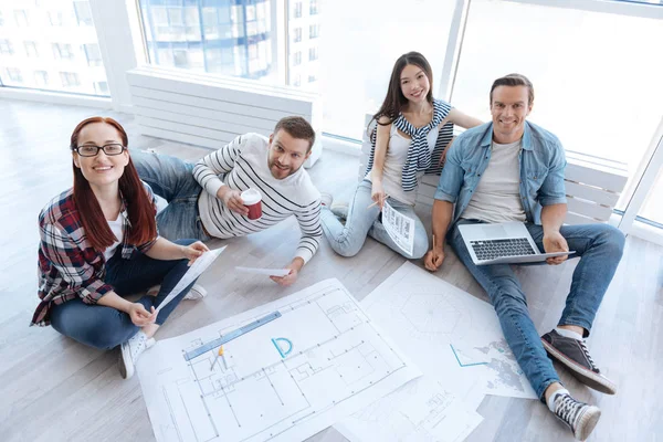 Equipo de jóvenes arquitectos positivos trabajando en el ambiente informal — Foto de Stock