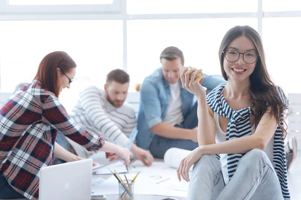 Feliz mujer alegre sosteniendo una manzana — Foto de Stock