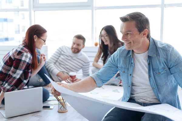 Joyful happy man looking at the drawing — Stock Photo, Image