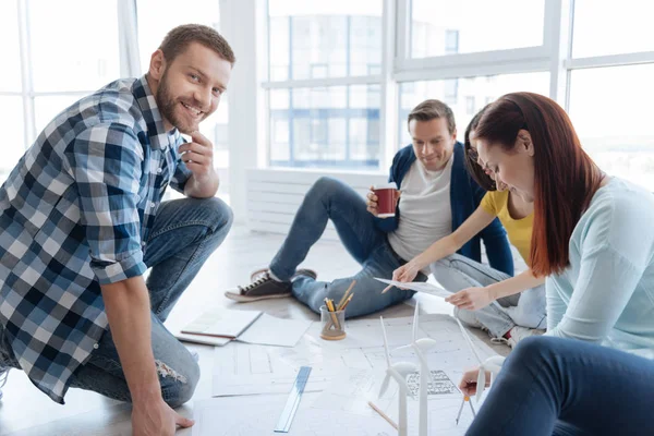 Encantado hombre positivo sentado con sus colegas — Foto de Stock