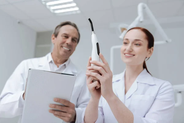 Trabalhadores médicos encantados positivos examinando novo instrumento — Fotografia de Stock