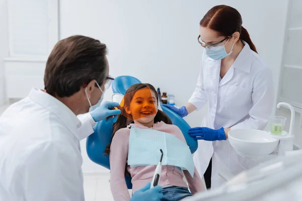 Funny patient kid smiling and looking through orange protection — Stock Photo, Image