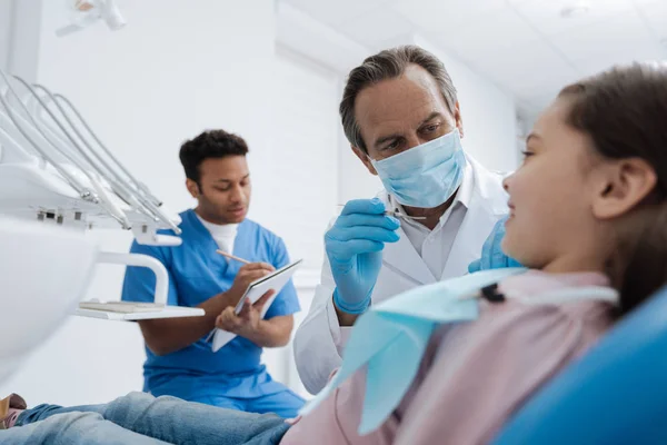 Entzücktes Mädchen liegt auf Stomatologenstuhl in Halbposition — Stockfoto