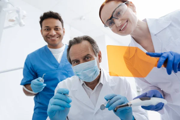 Tres trabajadores médicos sonriendo en sus rostros — Foto de Stock